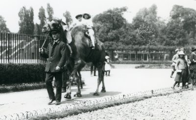 Deux jeunes visiteurs chevauchant un chameau de Bactriane, conduit par un gardien, au Zoo de Londres, août 1922 - Frederick William Bond